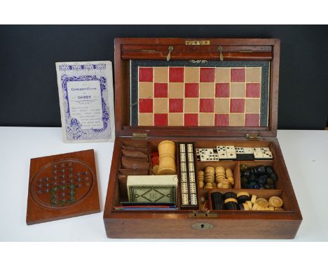 An early 20th century wooden cased games compendium to include Solitaire, Cribbage, Chess....etc. Complete with guide book. 