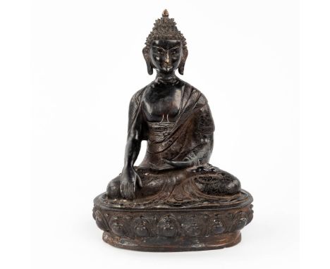 A Chinese figurine of Shakyamuni, patinated bronze.  (L: 16 x W: 24 x H: 35 cm)