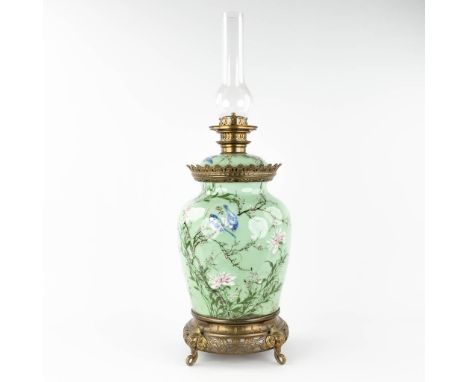 A Chinese celadon porcelain oil lamp, decorated with birds and flowers, mounted with bronze.Circa 1900.  (H: 79 x D: 26 cm)