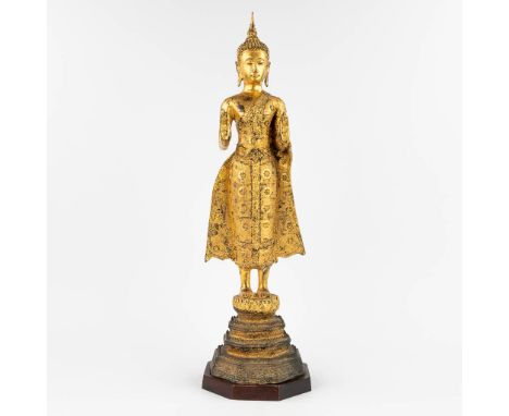 A Thai buddha, gilt bronze on a wood base.  (L: 19 x W: 19 x H: 69 cm)