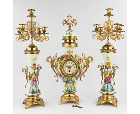 A three-piece mantle garniture clock and candelabra, hand-painted porcelain flower decor and mounted with brass. Circa 1900.H