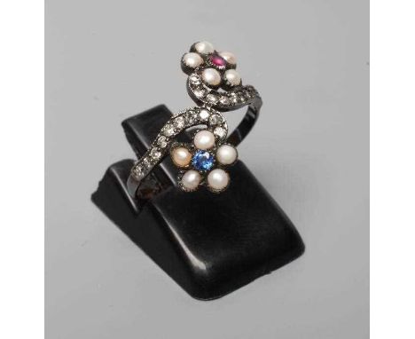 A GEORGIAN STYLE RING, the two off-set flower heads centred by a close back set blue and red stone within a seed pearl border