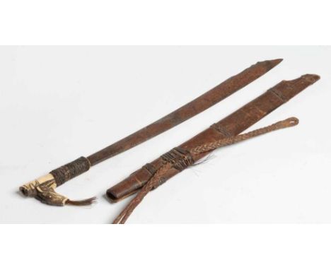 A DAYAK HEAD-HUNTER'S SWORD, the 21" blade shaped and decorated at the tip, carved bone handle, braided grip, horse hair pomm