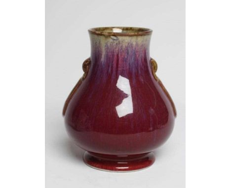 A CHINESE SANG DE BOEUF GLAZED VASE of baluster form with two fixed ring and tassel 'handles', with violet, lavender and cela