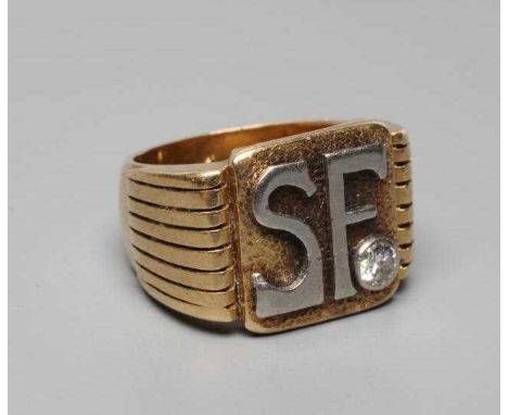 A GENTLEMAN'S DIAMOND SIGNET RING, the matt square panel applied with white metal intials SF with a brilliant cut diamond in 