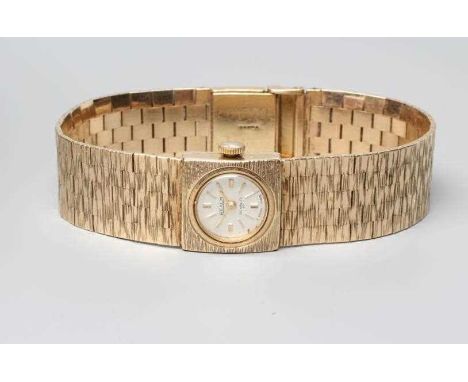 A LADY'S 9CT GOLD REALM WRISTWATCH, the silvered dial with gilt metal batons, the seventeen jewel Incabloc movement in a plai