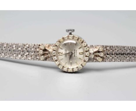 A LADY'S 18CT WHITE GOLD AND DIAMOND CURTIS WRISTWATCH, the silvered dial with applied Arabic quarter numerals, the seventeen