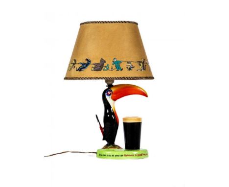 A CARLTONWARE GUINNESS TOUCAN LAMP BASE, mid 20th century, with original parchment type novelty printed shade, printed mark, 