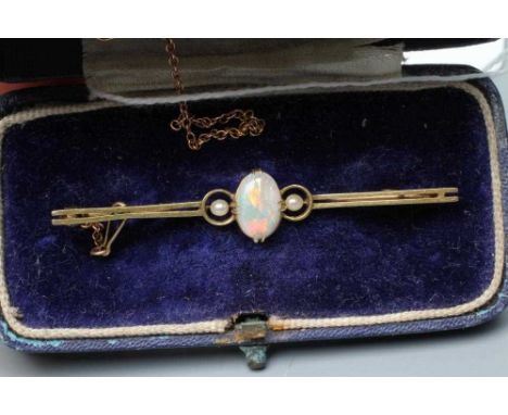 AN EDWARDIAN OPAL AND SEED PEARL BAR BROOCH, the claw set oval cabochon polished opal flanked by two seed pearls to a double 