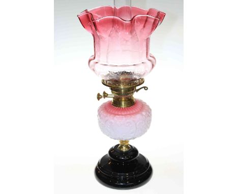 Oil lamp with pink tinted moulded glass reservoir and ruby tinted shade