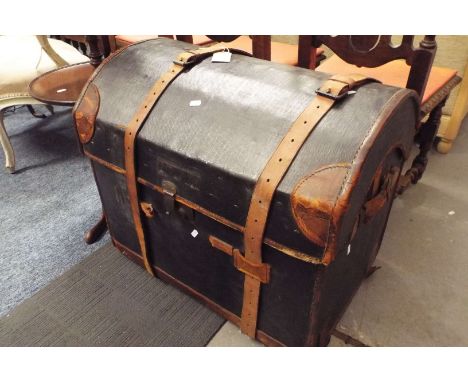A leather bound dome top travelling trunk