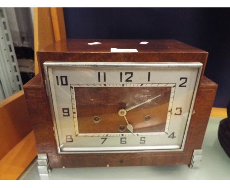 An Art Deco oak mantel clock with silvered ring dial and Arabic numerals (key inside)