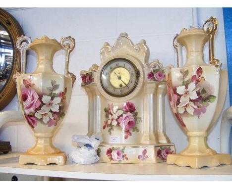 A ceramic floral patterned mantel clock, complete with garnitures 
