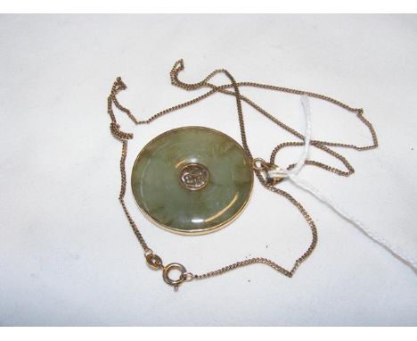 A circular jade pendant in gold setting and 14ct chain