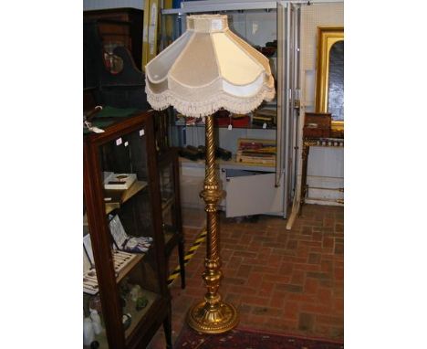 A decorative gilt standard lamp with fabric shade