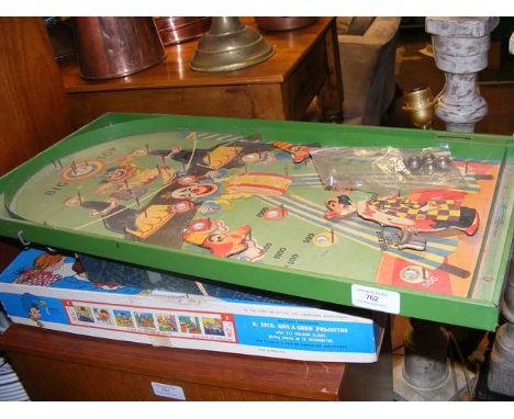 A vintage Chad Valley Give a Show Projector, Ernest Sewell Cabinet of Conjuring Tricks and a clown themed bagatelle board 