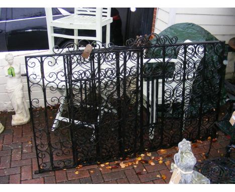 A pair painted of wrought iron gates together with a similar single gate