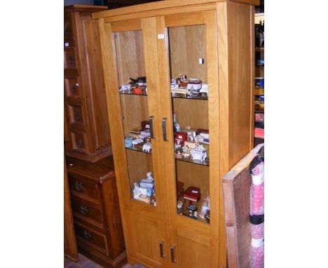 A light oak bookcase with glazed doors - width 91cm 