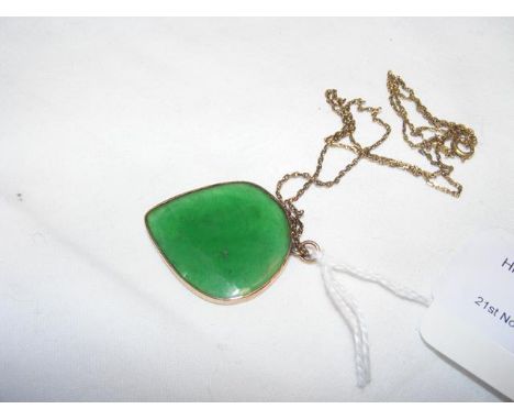 A shaped jade pendant with gold curb necklace marked 14ct CONDITION REPORT We have attached a number of additional images to 