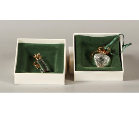 A lot consisting of (2) Swarovski Christmas Memories, depicting a pine cone and a golf bag. Both in original box. The First 1