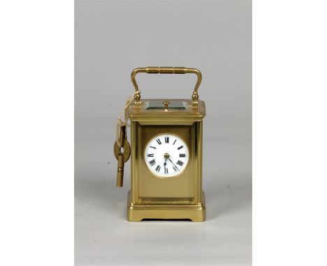 A brass travel alarm clock, white enamel dial shows the hours in Roman numerals, movement marked Aiguilles. France, late 19th