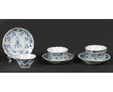 A set of porcelain saucers with 4x cups with floral decor and cachepot on the table decor in the center. China, 18th century.