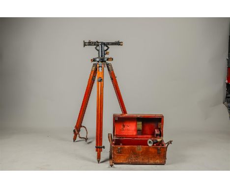 A surveying instrument or theodolite with accompanying tripod, extra lens and case. First half 20th century.