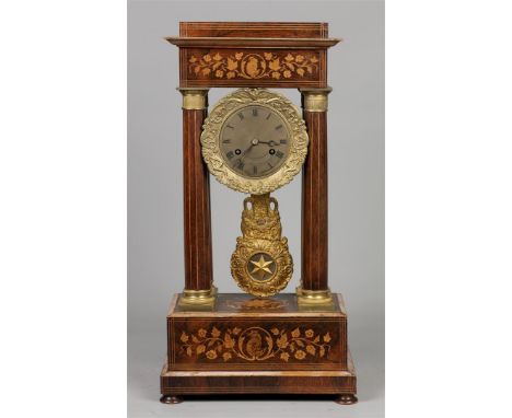 A mahogany column mantel clock with intarsia inlay of fruit wood, housing with straight columns. France, 19th century.H.: 47 