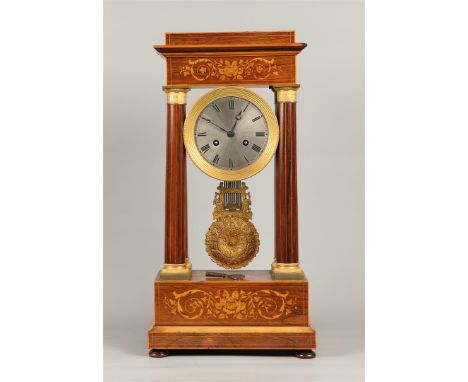 A mahogany column mantel clock with intarsia inlay of fruitwood housing with straight columns. France, 19th century.H.: 54,5 