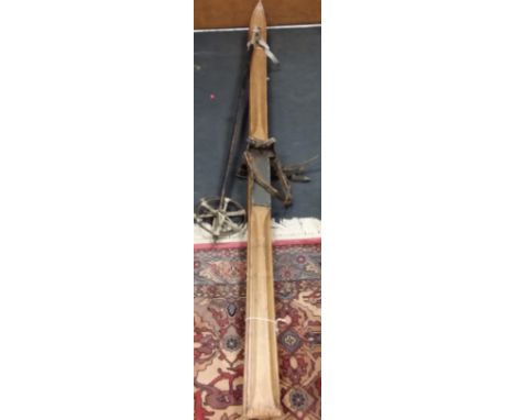 A pair of vintage wooden skis and poles stamped Baumann Vevey
