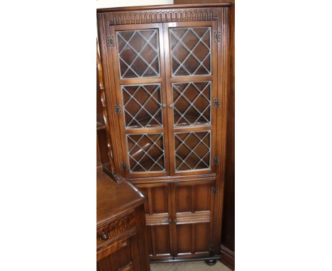 A 20th century oak standing corner cupboard and a set of four ladder back dining chairs