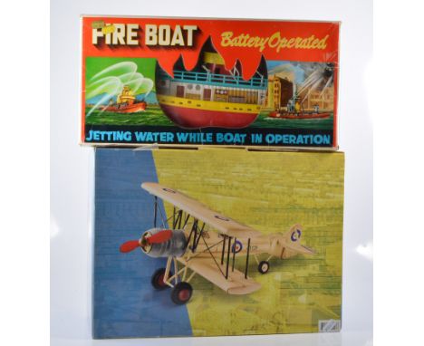 Vintage battery operated fire boats, boxed, with a Wembley six hole golf set and a metal model Bi-plane, boxed, (3). 