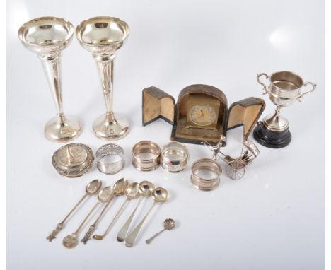 A Zenith travel alarm clock, 5cm, in a small two door case, a pair of silver 19cm trumpet vases (af), four silver napkin ring