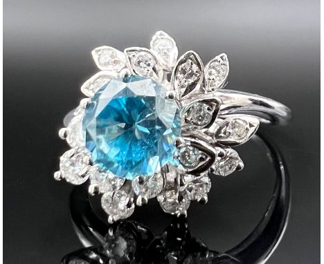 Damenring. 585 Weißgold mit kleinen Diamanten und einem blauen Farbstein.Circa 4,6 Gramm Gesamtgewicht. Ring in Blumenform. F
