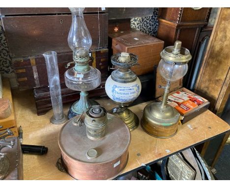 Four assorted brass copper and ceramic oil lamps including a box of assorted replacement wicks, mantles and a glass measure.