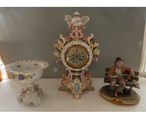 A tall German ceramic clock 46cm high, one foot has been repaired, A Naples ( Capodimonte) large group of a tramp on a bench 