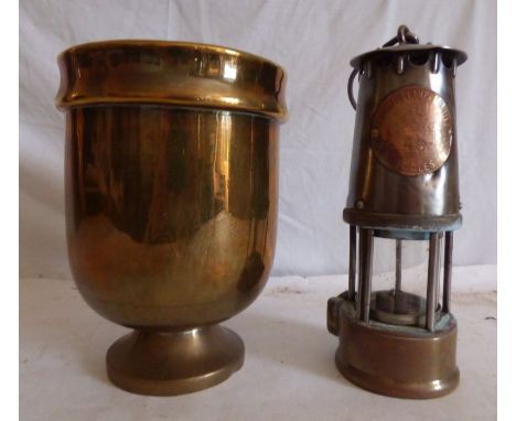 A Minors lamp and brass trophy vase, inlay on lamp reads Protector lamp and light company, type SL 43 Eccles. 23 cm high (2)