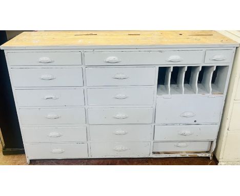 A 20th century painted pine shop drawer unit, rectangular shaped above an arrangement of drawers and pigeonholes, mounted wit