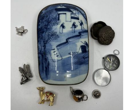 A white metal box inlaid with a blue and white porcelain lid, depicting Chinese figures, along with a selection of decorative