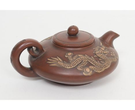 Chinese Yixing teapot, squat form carved with scrolling dragons, the base with a Zhuanshu seal mark, height 8cm 