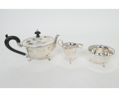 Silver composite three piece tea service, comprising teapot, maker ESB, Birmingham 1945, plain U-shape raised on stepped hoof