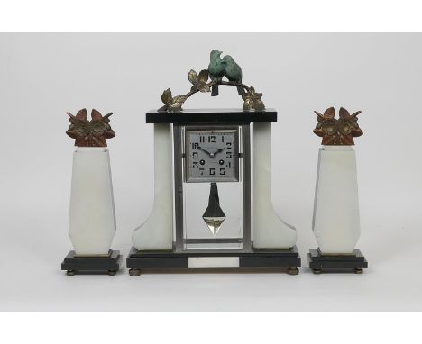 French Art Deco mantel clock garniture, the clock surmounted with lovebirds in patinated metal, over a square dial signed 'De