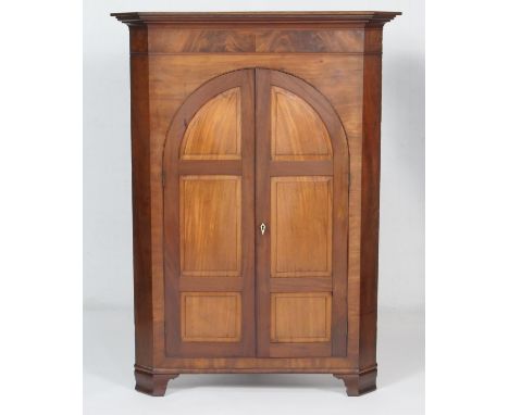 Mahogany free standing flat front corner cupboard, 19th Century and later, having arched fielded panel doors opening to shape