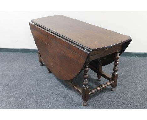 A Georgian oak gate leg table with peg top fitted a drawer 