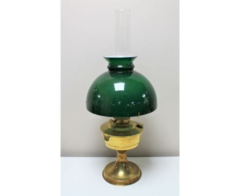 An antique brass Aladdin oil lamp with green glass shade and chimney 