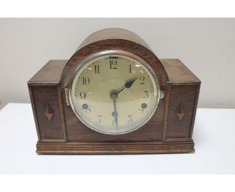 A 1930's oak cased mantel clock with silvered dial 