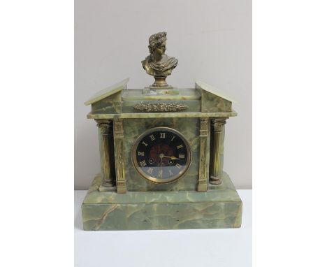 An antique onyx and brass mantel clock surmounted by a brass bust 