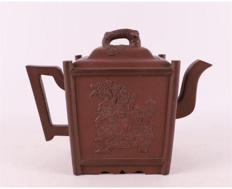 A square yixing stoneware teapot, China, circa 1900. Relief decoration with among other things chrysanthemums on a rock, lid 