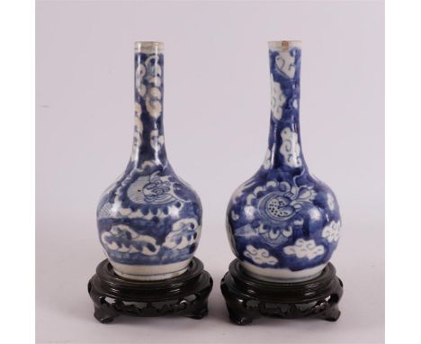 A pair of blue and white porcelain long neck vases, China, 18th century. Blue underglaze decoration of dragons with flaming p