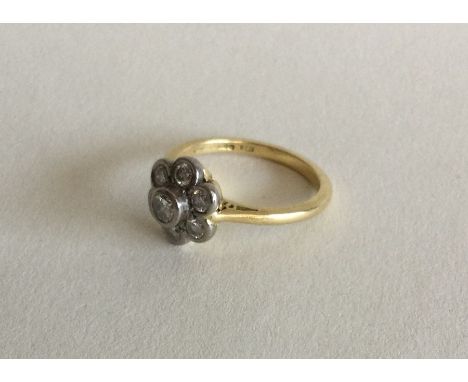 A heavy circular daisy head cluster ring set in 18 carat gold and platinum. Approx. 4 grams. Est. £100 - £150.